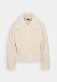 Giacca in pelliccia sintetica color crema con colletto, chiusura a zip completa e maniche lunghe. Texture morbida, vestibilità rilassata e senza motivi visibili.