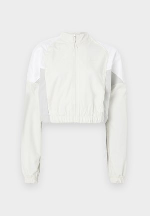 Κοντό μπουφάν σε ανοιχτό γκρι με φερμουάρ στο μπροστινό μέρος. Διαθέτει ελαστικές μανσέτες και πάνελ σε αντίθετο λευκό χρώμα. Ελαφρύ, με απαλή υφή.