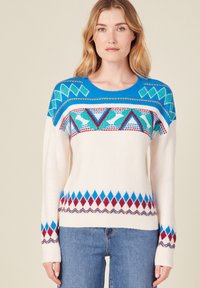 Strickpullover in Creme mit geometrischen Mustern in Blau, Rot und Türkis. Hat einen runden Halsausschnitt und gerippte Bündchen, mit einem Rautendesign am Saum.