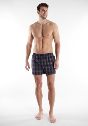 Marineblau kariertes Boxershorts mit elastischem Bund, verziert mit roten und grünen Streifen. Hergestellt aus weichem Material, knielang, minimalistisches Design.