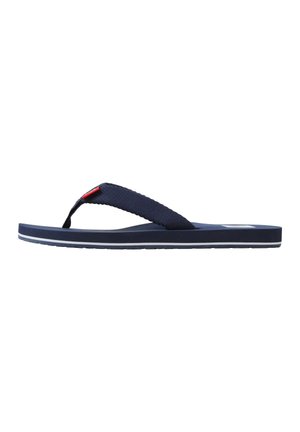 Marineblauwe teenslipper met stoffen bandjes en een platte zool, zijaanzicht op een witte achtergrond.