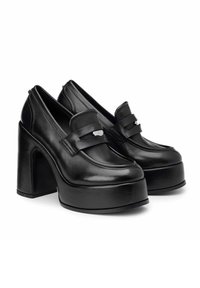 Scarpe platform in pelle nera con tacco largo, caratterizzate da una punta arrotondata e una fascia decorativa sulla tomaia con dettagli metallici.