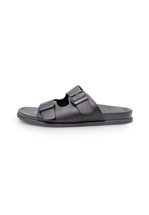 Sandales glissantes en cuir noir avec deux sangles à boucle ajustables, design à bout ouvert, semelle plate et texture lisse.