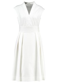 Vestido blanco sin mangas con escote en V, cuerpo ajustado y falda plisada y fluida. Textura suave, diseño minimalista y sin patrones visibles.