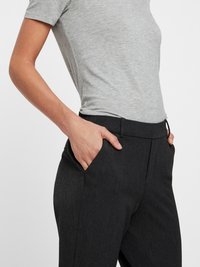 Gray fitted t-shirt paired with dark gray, textured, tailored pants featuring side pockets and a smooth waistband.