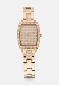 Rektangulær rose-guld ur med en krystalkant, tekstureret pink urskive og metalled. Den har diskrete timemarkører og visere.
