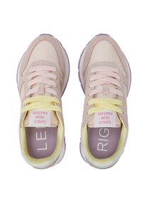 Zapatillas de deporte en rosa claro con acentos amarillos, con parte superior de malla, cuello acolchado y suela de goma morada. Las etiquetas dicen "LAS CHICAS CORREN MÁS RÁPIDO."