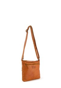 Sac bandoulière en cuir marron avec une sangle ajustable, un compartiment principal zippé et une poche avant avec un patch logo. Texture lisse et forme rectangulaire.