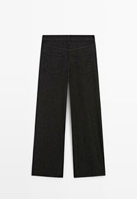 Schwarze Jeans mit weitem Bein, von hinten gezeigt mit zwei Gesäßtaschen und Gürtelschlaufen.