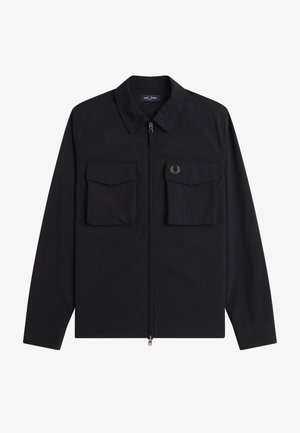 Chemise noire à manches longues avec fermeture éclair, col et deux poches à rabat à l'avant, arborant un petit logo de couronne de laurier sur la poche droite.