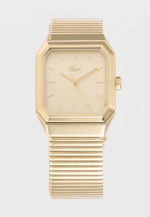 Ceas de mână rectangulare Lacoste în tonuri de aur, cu brățară metalică striată, cadran minimalist și logo cu crocodil la poziția orei 12.