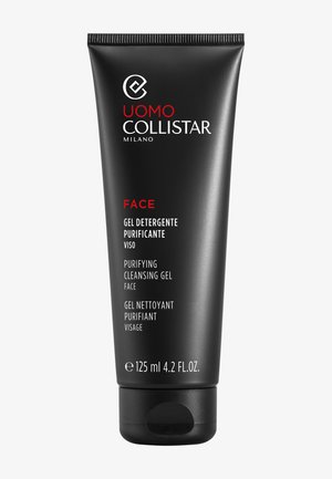 Zwarte geperste tube met een matte afwerking, voorzien van witte en rode tekst, gelabeld "Purifying Cleansing Gel." Formaat: 125 ml. Afgeronde dop.