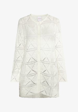 Bijela pletena kardigan s geometrijskim uzorkom, dugim rukavima, okruglim izrezom i kopčanjem s gumbima sprijeda. Teksturirana tkanina.