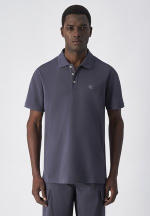 Polo shirt blu navy con colletto classico, placket a due bottoni e maniche corte. Presenta un piccolo logo sul lato sinistro del petto. Tessuto di cotone liscio.