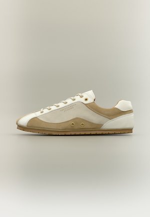Sneaker a profilo basso beige e bianco con design con lacci, marchiata "Copenhagen Studios" sul lato, mostrata su sfondo neutro.