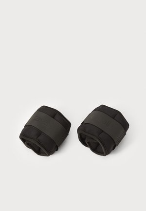 Black fabric wrist weights with padded sections, secured by dark elastic bands. Smooth texture with a minimalist design, compact and portable.
