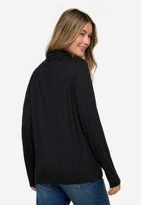 Top nero a maniche lunghe con colletto alto, realizzato in un morbido tessuto elasticizzato. Design semplice, vestibilità comoda e texture liscia.