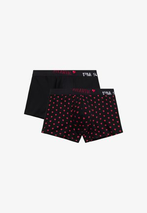 Dwie pary czarnych męskich bokserek, jedna gładka, druga z czerwonym wzorem serc, obie z markowymi paskami w talii z czerwono-białym napisem.