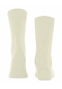 Skarpetki dzianinowe w jasnym kremowym kolorze z prążkowanym wykończeniem na górze. Posiadają wzmocnione pięty i palce. Miękka tekstura oraz elastyczne dopasowanie dla wygody.