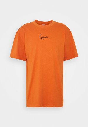 Camiseta naranja de manga corta de algodón con cuello redondo y pequeño logo negro en cursiva centrado en el pecho sobre fondo blanco.
