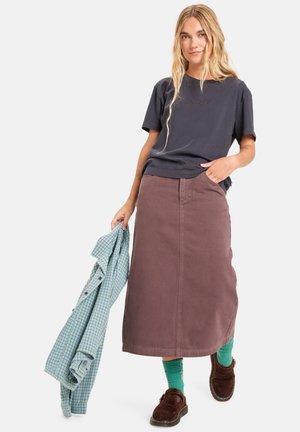 Tmavě šedé bavlněné tričko, hnědá bavlněná midi sukně, zelená kostkovaná košile přehozená, zelené ponožky, hnědé boty, volný outfit s kapsami.