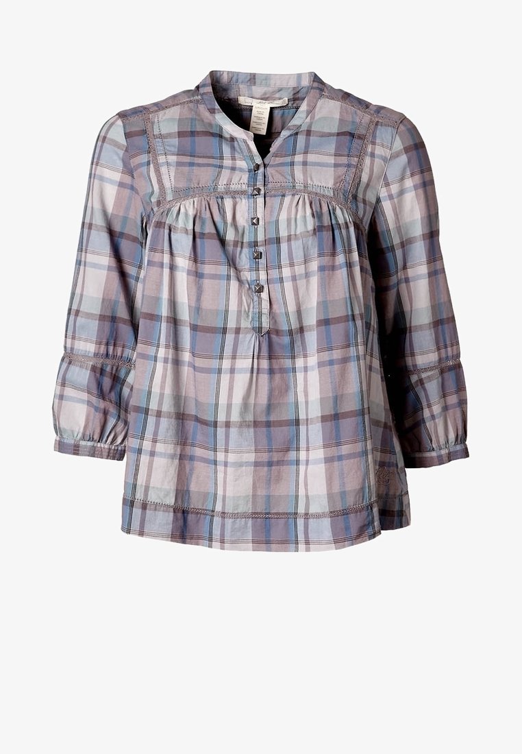 Blouse à manches longues avec motif à carreaux bleu, gris et violet, boutonnée à l'avant et tissu légèrement froncé sous la poitrine.
