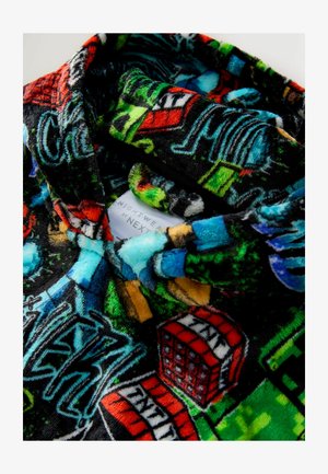 Patalynės viršus iš fliso, turintis juodą foną su spalvingais grafikos ir raštų elementais, įskaitant pastatus ir tekstinius elementus. Etiketė matoma.