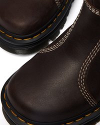 Donkerbruine leren laarzen met een ronde neus, contrasterende gele stiksels en een rubberen zool. Heeft decoratieve stiksels langs de zijkanten.
