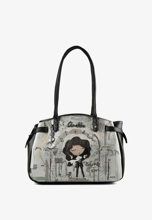 Sac à main avec poignées noires représentant une femme en dessin animé chantant sur scène, des notes de musique et une petite illustration de chat dans des tons gris et noirs atténués.
