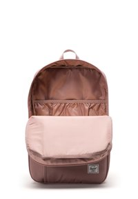 Mochila Herschel en tejido rosa apagado, con un compartimento principal con cremallera, bolsillos interiores y una solapa frontal con una etiqueta de logo.