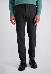 Pantalons gris foncé avec un motif en chevrons subtil, coupe ajustée et bouton unique à l'avant ; associés à des chaussures brogues noires.