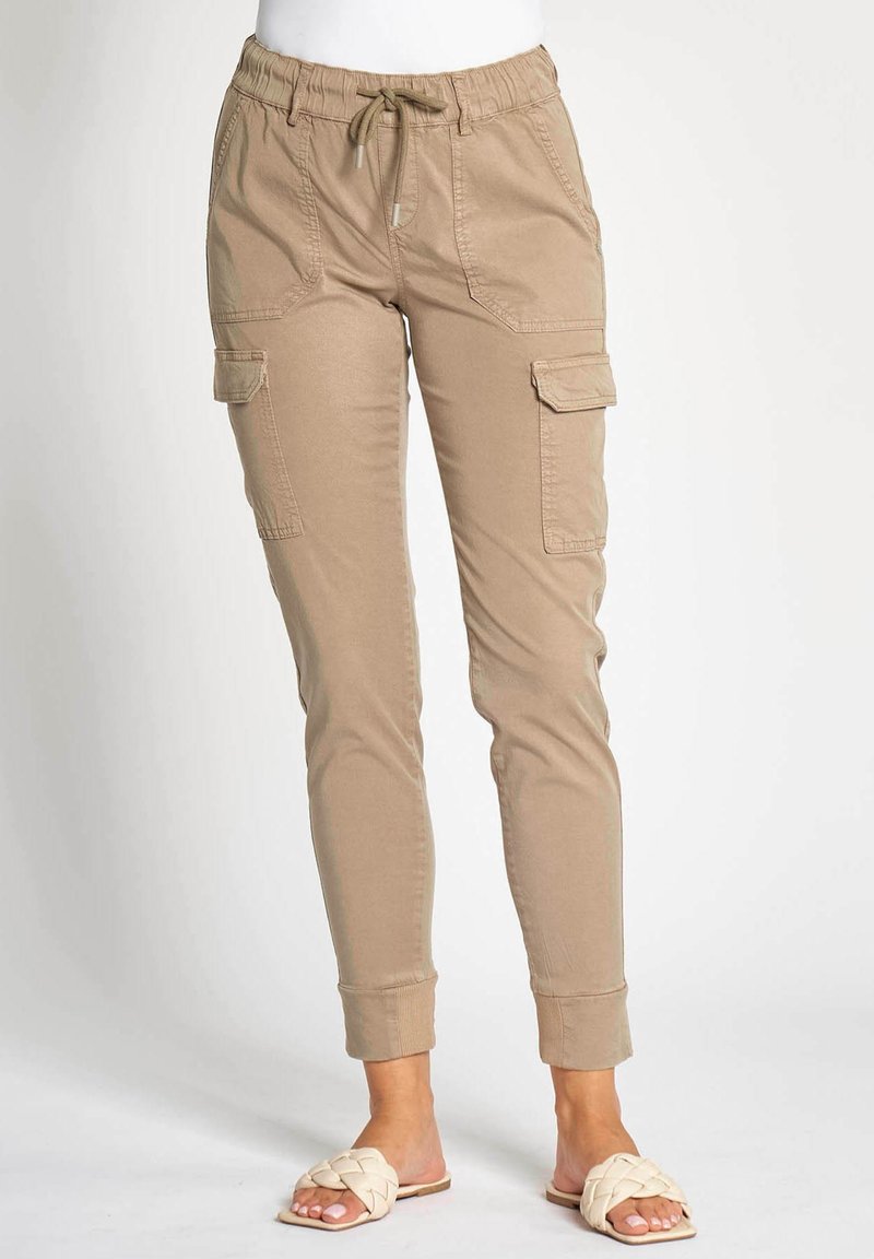 Beige Cargohose mit elastischem Bund, Kordelzug und zwei Seitentaschen. Bündchen an den Knöcheln. Glatter, strapazierfähiger Stoff.