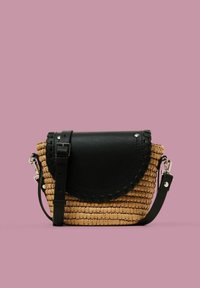Tkaná slaměná kabelka s černým koženým klopovým víkem a detailem šití, s odnímatelným popruhem a stříbrnými kovovými akcenty.