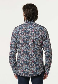 Langarmshirt in donker marineblauw met een bloemenpatroon in roze, groen en wit. Beschikt over een kraag en knoopmanschetten. Casual ontwerp.