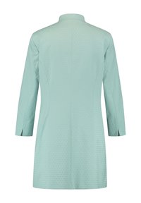 Manteau en tissu léger vert menthe avec un motif en diamants subtil, col montant, manches trois-quarts, et silhouette cintrée.