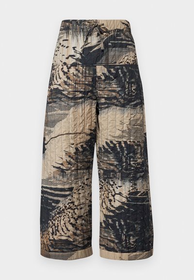 Quilted wide-leg trousers in beige and black with abstract patterns and a drawstring waist. Textured surface with horizontal lines.