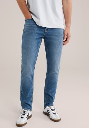 Blauwe denim jeans met een taperende pasvorm en subtiele vervaging. Heeft een klassiek vijf-pocket ontwerp, gestikte naden en een versleten textuur.