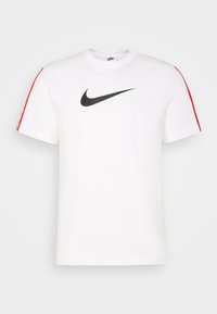 Bílý bavlněný tričko s krátkým rukávem, na přední straně s velkým černým logem Nike a červenými akcenty na ramenou.