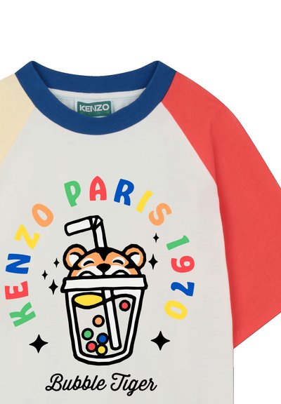 T-shirt pour jeunes avec manches raglan rouges, bleues et beiges. Corps blanc avec texte coloré « KENZO PARIS 1970 » et graphique ludique « Bubble Tiger ».