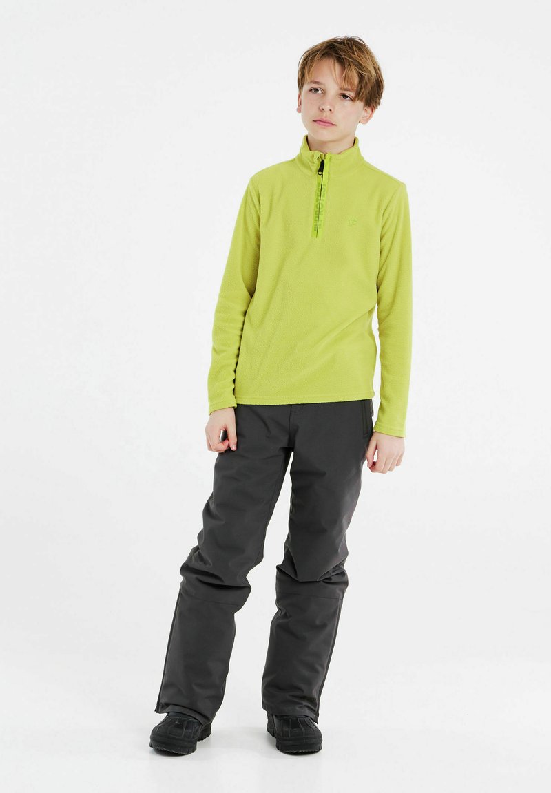 Pullover in pile verde con zip a metà, pantaloni isolati neri e stivali impermeabili neri, progettati per attività all'aperto.