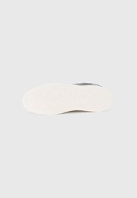 Μαύρο αθλητικό παπούτσι με λείο επάνω μέρος, λευκή λαστιχένια σόλα με υφή και λογότυπο ανάγλυφο στην εσωτερική σόλα.