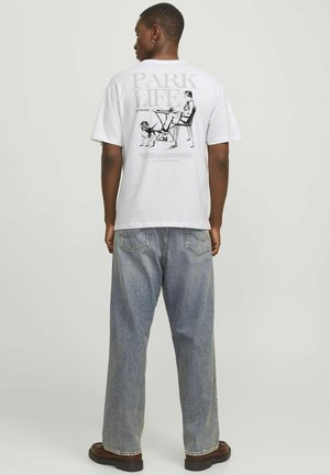 Hvid bomulds t-shirt med grafisk print på ryggen, hvor der står "PARK LIFE" og en illustreret scene af en person og en hund.