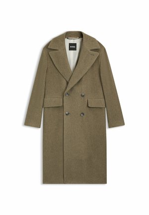 Manteau en laine herringbone vert olive avec fermeture à double boutonnage, larges revers et deux poches avant. Intérieur doublé.