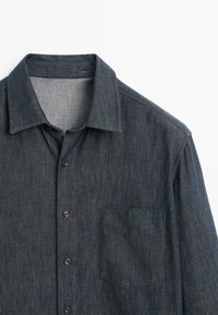 Jeanshemd, dunkelblau, lange Ärmel, Knopfverschluss vorne, einzelne Brusttasche, dezente Textur und klassisches Kragen Design.