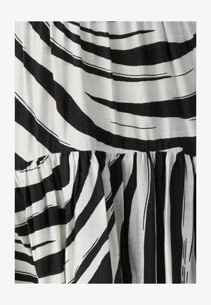 Melnas un baltas svītras audums ar fakturētu virsmu, raksturots ar izteiktām viļņainām līnijām un savāktu šuvi, radot slāņveida izskatu.