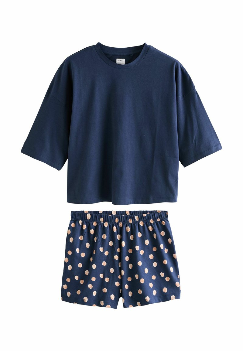 Camiseta corta de manga corta azul marino combinada con pantalones cortos azul marino con un patrón de lunares beige claro y cintura elástica.