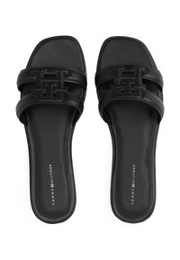 Sandalias de slide negras con puntera cuadrada, que presentan dos correas anchas grabadas con un patrón de logo, textura de cuero suave y suelas planas.
