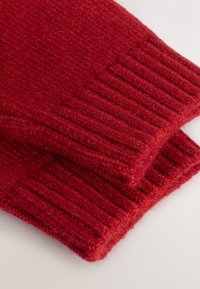 Écharpe en laine rouge foncé tricotée avec une texture côtelée. Présente des bords repliés et une apparence douce, adaptée pour la chaleur et le confort.