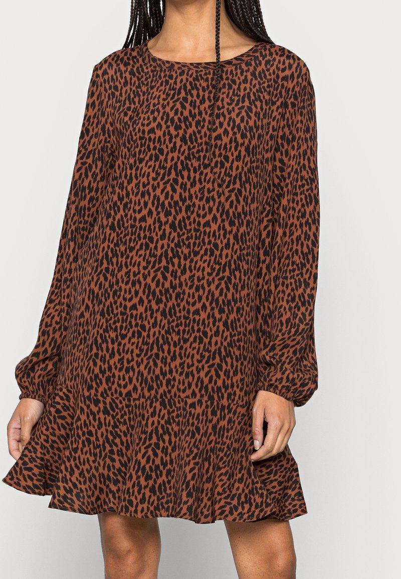 Braun geflecktes Kleid mit langen Ärmeln, rundem Ausschnitt und einem rüschengesäumten Saum. Hergestellt aus leichtem Material, bietet es einen lockeren Schnitt.