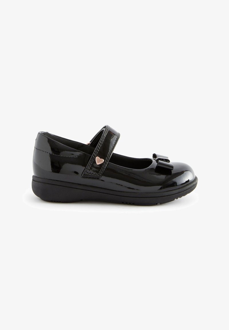 Chaussure Mary Jane en cuir verni noir avec un nœud sur le bout, une bride velcro avec un petit détail en forme de cœur et une semelle basse de soutien.